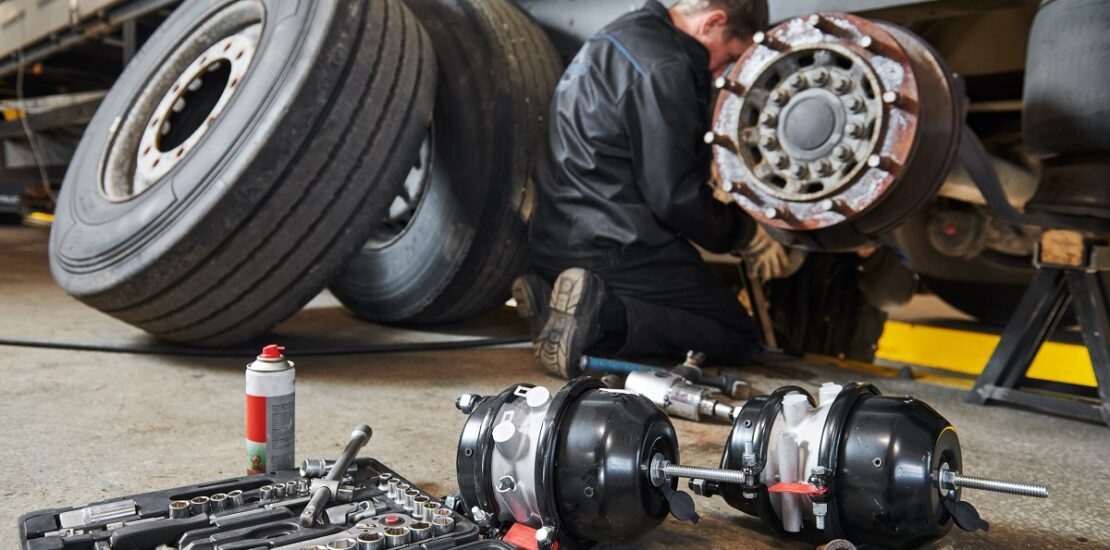 Truck repair service. Mechanic takes off tyre for brake replacement