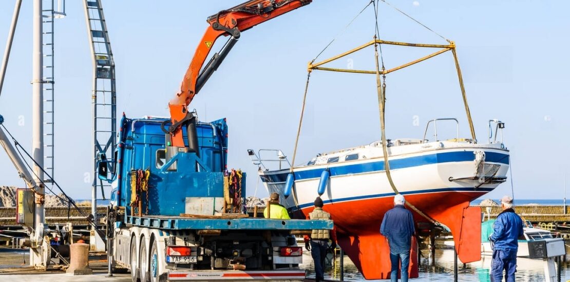 skanor-sweden-april-28-2018-travel-documentary-of-everyday-life-and-place-the-launch-of-a-sailboat-in-the-docks-using-a-mobile-crane-on-a-windle-MMAKRG 2